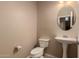 A clean half bathroom featuring a pedestal sink and comfort height toilet at 19072 N Ventana Ln, Maricopa, AZ 85138