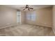 A neutral-toned bedroom with carpet, ceiling fan, and closet visible through the door at 19072 N Ventana Ln, Maricopa, AZ 85138