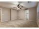 Neutral bedroom boasts a ceiling fan, plush carpeting, and a view into the closet at 19072 N Ventana Ln, Maricopa, AZ 85138