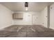An empty garage with cabinets and a door to access the home's interior at 19072 N Ventana Ln, Maricopa, AZ 85138