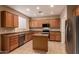 Well-lit kitchen with stainless steel dishwasher and appliances, light wood cabinets, and a functional kitchen island at 19072 N Ventana Ln, Maricopa, AZ 85138