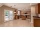 Bright kitchen features tile flooring, stainless steel appliances, and light wood cabinetry with access to the backyard at 19072 N Ventana Ln, Maricopa, AZ 85138