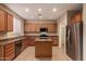 Well-lit kitchen featuring an island, stainless steel appliances, and plenty of wooden cabinetry at 19072 N Ventana Ln, Maricopa, AZ 85138
