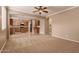Open concept living room with plush carpet, ceiling fan, and access to the kitchen at 19072 N Ventana Ln, Maricopa, AZ 85138