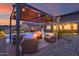 Stunning backyard featuring a pergola with seating, fire pit, lush landscaping and sparkling pool, perfect for outdoor entertaining at 19443 W Valle Vista Way, Litchfield Park, AZ 85340