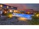 Expansive backyard showcases a shimmering pool, outdoor kitchen area, dining space, and lounge area, perfect for entertaining at 19443 W Valle Vista Way, Litchfield Park, AZ 85340