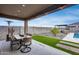 Covered outdoor dining area with patio furniture, gas heater, backyard, artificial turf, and sky views at 19443 W Valle Vista Way, Litchfield Park, AZ 85340