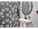 Powder room features elegant wallpaper, pedestal sink and modern matte black finishes at 19443 W Valle Vista Way, Litchfield Park, AZ 85340