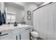 Clean bathroom featuring a vanity, toilet, shower with curtain, and decorative mirror at 19443 W Valle Vista Way, Litchfield Park, AZ 85340