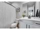 Bright bathroom featuring a white vanity, modern black fixtures, and a patterned shower curtain at 19443 W Valle Vista Way, Litchfield Park, AZ 85340