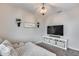 Cozy bedroom featuring a soft couch, modern light fixture, and entertainment center with a TV at 19443 W Valle Vista Way, Litchfield Park, AZ 85340