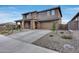 Inviting two-story home with a wide driveway, stone accents, well-manicured landscaping, and a two car garage at 19443 W Valle Vista Way, Litchfield Park, AZ 85340