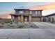 Two-story home with a two-car garage, stone-clad porch columns, and professionally landscaped front yard at 19443 W Valle Vista Way, Litchfield Park, AZ 85340