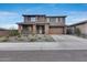 Two-story home with a two-car garage, stone-clad porch columns, and professionally landscaped front yard at 19443 W Valle Vista Way, Litchfield Park, AZ 85340
