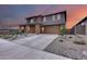 Two-story home featuring stone-clad porch columns, desert landscaping, and a concrete driveway to the two-car garage at 19443 W Valle Vista Way, Litchfield Park, AZ 85340