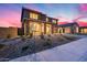 Stylish two-story home featuring stone columns, desert landscaping and beautiful sunset at 19443 W Valle Vista Way, Litchfield Park, AZ 85340
