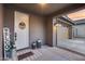 Covered front porch, featuring 'Welcome' decor and two carriage lights, located by a two-car garage at 19443 W Valle Vista Way, Litchfield Park, AZ 85340