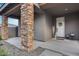 Covered front porch with stone columns, 'Welcome' decor, and two carriage lights, leading to the front door at 19443 W Valle Vista Way, Litchfield Park, AZ 85340