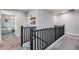 Hallway view with black metal railing, carpet, and view to the next room at 19443 W Valle Vista Way, Litchfield Park, AZ 85340
