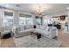 Bright living room with plush sectional, large windows, and wood floors, offering ample seating at 19443 W Valle Vista Way, Litchfield Park, AZ 85340