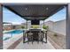 Covered outdoor dining area with built-in fire pit and seating, ideal for entertaining guests at 19443 W Valle Vista Way, Litchfield Park, AZ 85340
