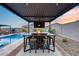 Outdoor entertainment area featuring a pergola with a table, chairs, and TV at 19443 W Valle Vista Way, Litchfield Park, AZ 85340