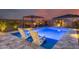 Inviting backyard featuring a luxurious pool with tanning ledge, pergola and lounge chairs at 19443 W Valle Vista Way, Litchfield Park, AZ 85340