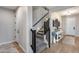 Hallway with carpeted staircase with black railing and white trim near console table and entrance at 19443 W Valle Vista Way, Litchfield Park, AZ 85340