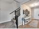 Hallway with a carpeted staircase with black railing and white trim, next to console table at 19443 W Valle Vista Way, Litchfield Park, AZ 85340