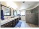 Bright bathroom boasting dual sink vanity, gray tile, and large shower at 19622 N 66Th Ln, Glendale, AZ 85308