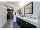 Bathroom featuring dual sink vanity, open closet, and a modern design at 19622 N 66Th Ln, Glendale, AZ 85308