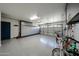 Clean, organized garage with epoxy flooring, overhead lighting, and ample storage cabinets at 19622 N 66Th Ln, Glendale, AZ 85308