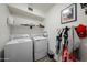 Functional laundry room with washer, dryer, shelving, and decor, perfect for home organization at 19622 N 66Th Ln, Glendale, AZ 85308