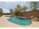 Inviting pool with rock waterfall feature, surrounded by lush landscaping and privacy walls at 19622 N 66Th Ln, Glendale, AZ 85308
