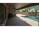 Covered patio with ceiling fan overlooks a pebble tec pool with desert landscaping at 19622 N 66Th Ln, Glendale, AZ 85308