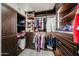 Organized walk-in closet features custom shelving, drawers, and hanging rods with warm, wood finishes at 19622 N 66Th Ln, Glendale, AZ 85308