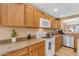 Well-lit kitchen featuring oak cabinets, neutral countertops, and modern white appliances at 21816 E Puesta Del Sol --, Queen Creek, AZ 85142