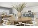 Open dining area with a round wooden table, stylish chairs, and seamless flow to the kitchen at 25461 W Graham Trl, Buckeye, AZ 85326