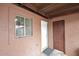 Exterior view of the rear entrance with a white door and adjacent basement door, featuring a window at 2619 W Lamar Rd, Phoenix, AZ 85017