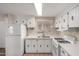 Well-lit kitchen featuring appliances, ample counter space, white cabinets, and a double sink at 2650 W Union Hills Dr # 350, Phoenix, AZ 85027