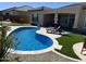 Inviting backyard features a kidney shaped pool, artificial grass, and cozy lounge chairs at 26904 W Kerry Ln, Buckeye, AZ 85396