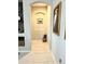 Hallway featuring decorative niches, neutral paint, and light tile flooring at 26904 W Kerry Ln, Buckeye, AZ 85396