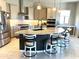 Well-lit kitchen with stainless steel appliances, granite countertops, an island, and bar seating at 26904 W Kerry Ln, Buckeye, AZ 85396