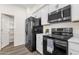 Galley kitchen with black appliances, white cabinets, and a pantry for additional storage at 2765 S Cavalier Dr # 102, Gilbert, AZ 85295