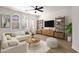 Bright living room featuring a modern sofa, arched windows, ceiling fan and stylish shelving at 2765 S Cavalier Dr # 102, Gilbert, AZ 85295