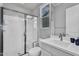 Bright bathroom showcasing a glass-enclosed shower, modern vanity, and a window at 2854 E Cashman Dr, Phoenix, AZ 85050