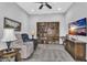 Carpeted living room with a large bookcase, a television, and a recliner for comfortable seating at 2854 E Cashman Dr, Phoenix, AZ 85050