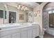 Bathroom with a dual sink vanity, bright lighting, an arched doorway, and a bathtub at 3258 E Vogel Ave, Phoenix, AZ 85028