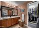Bathroom featuring a dual sink vanity, a large mirror, warm lighting, and a walk-in closet at 3258 E Vogel Ave, Phoenix, AZ 85028