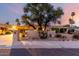 Charming single-story home with desert landscaping, mature trees, and a well-maintained stucco facade at sunset at 3258 E Vogel Ave, Phoenix, AZ 85028